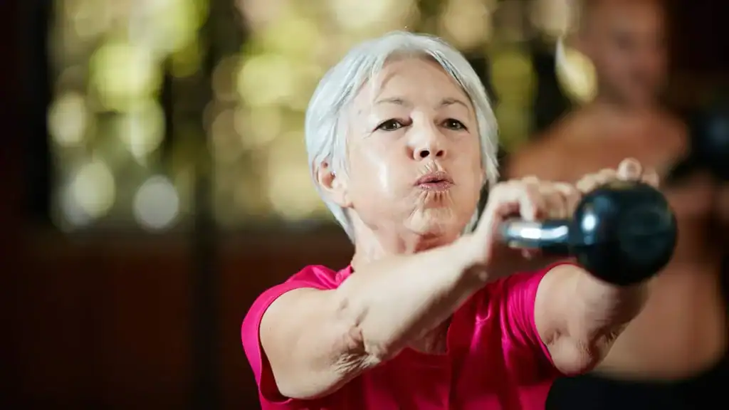 Toning Arms After 60: Empowering Womens Fitness Through Effective Weight Training 1 Older woman doing weight training Virginia Water to help her strength and longevity