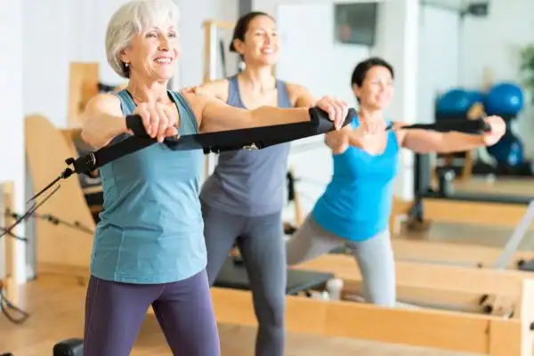 Toning Arms After 60: Empowering Womens Fitness Through Effective Weight Training 2 older woman doing weight training Virginia Water and resistance in the gym to tone upper arms