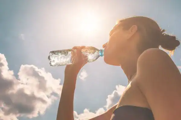 Hydration: The Secret Ingredient for a Toned Stomach and Enhanced Fitness 3 Image of woman drinking water to hydrate Virginia Water after run.
